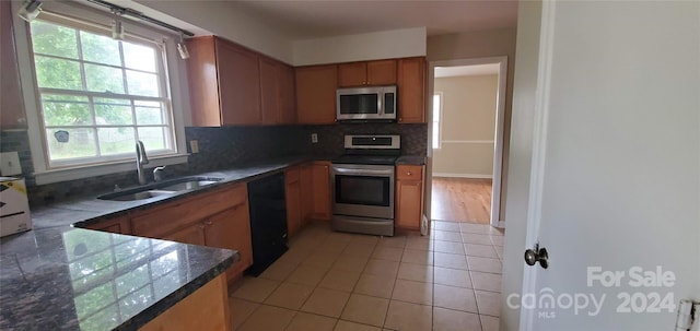 kitchen with stainless steel appliances, light tile patterned flooring, sink, and backsplash