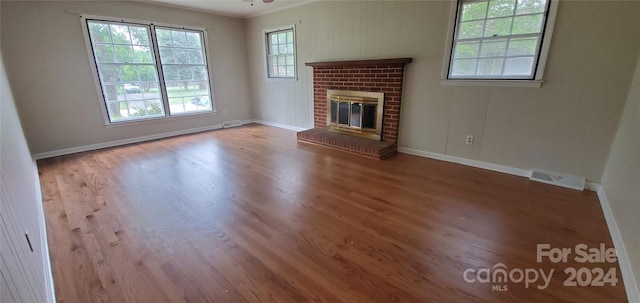 unfurnished living room with ornamental molding, a fireplace, hardwood / wood-style flooring, and ceiling fan