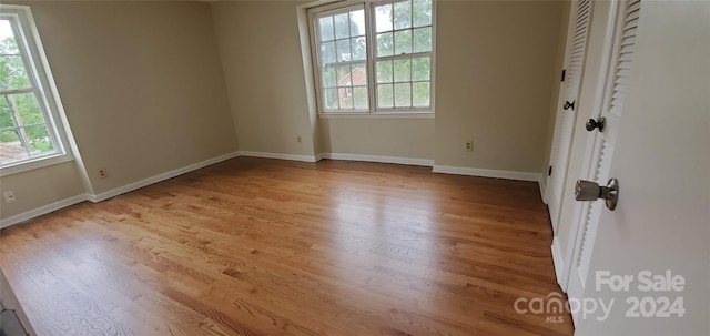 unfurnished bedroom with light wood-type flooring and multiple windows