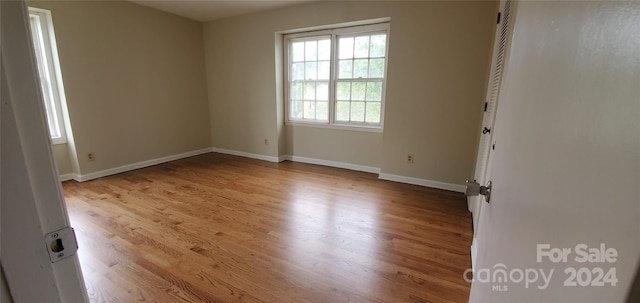 unfurnished room with light wood-type flooring