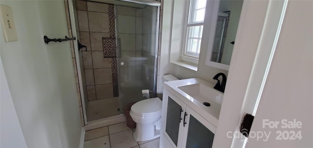 bathroom with vanity, a shower with door, tile patterned floors, and toilet