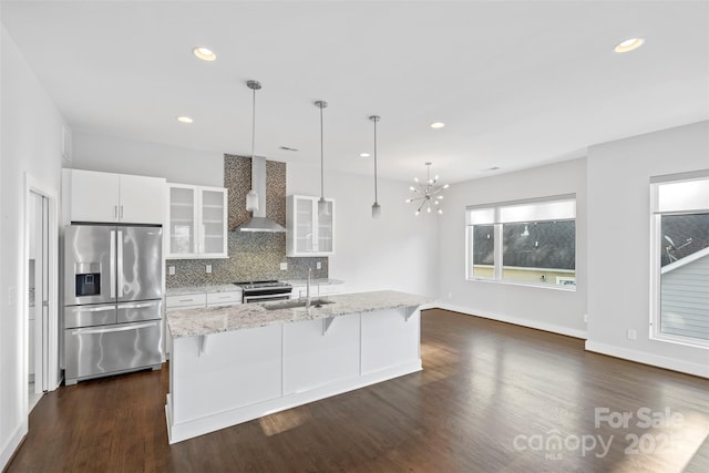 kitchen featuring white cabinets, sink, a breakfast bar area, wall chimney exhaust hood, and stainless steel appliances