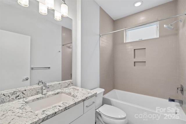 full bathroom with vanity, tiled shower / bath combo, and toilet