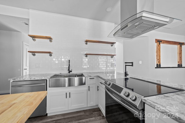 kitchen featuring island exhaust hood, stainless steel appliances, white cabinetry, dark hardwood / wood-style flooring, and light stone countertops