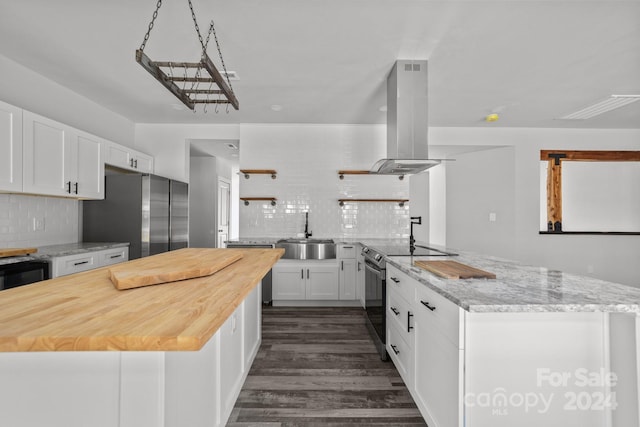 kitchen with island exhaust hood, stainless steel appliances, sink, white cabinets, and dark wood-type flooring