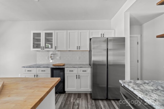 kitchen with dark wood-type flooring, stainless steel refrigerator, white cabinetry, and beverage cooler