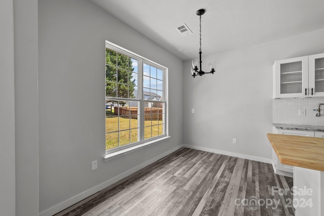 unfurnished dining area featuring a chandelier and light hardwood / wood-style floors