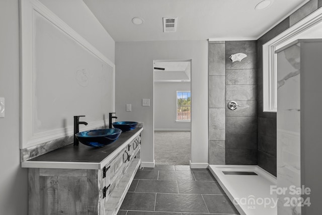 bathroom featuring vanity, tile patterned floors, and tiled shower