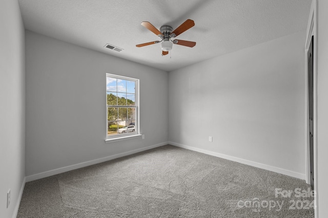 empty room with carpet floors, a textured ceiling, and ceiling fan