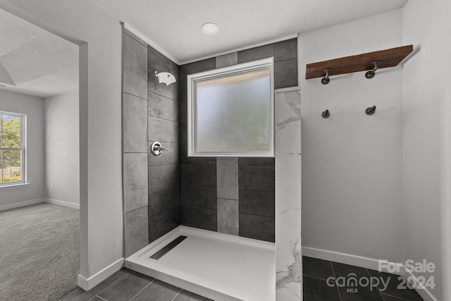 bathroom featuring tile patterned flooring and tiled shower