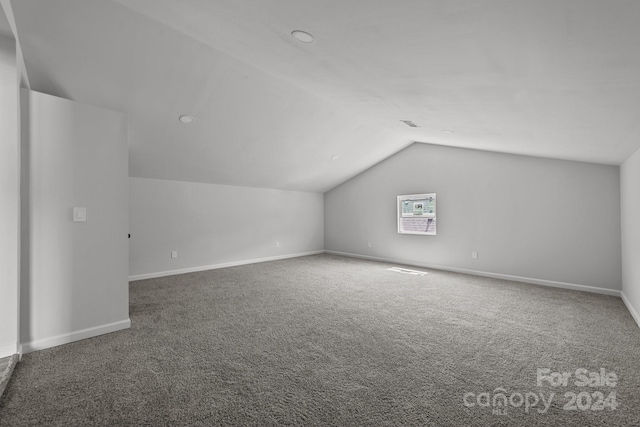 bonus room with vaulted ceiling and carpet floors