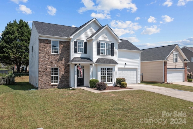 view of front of home with a front lawn and a garage