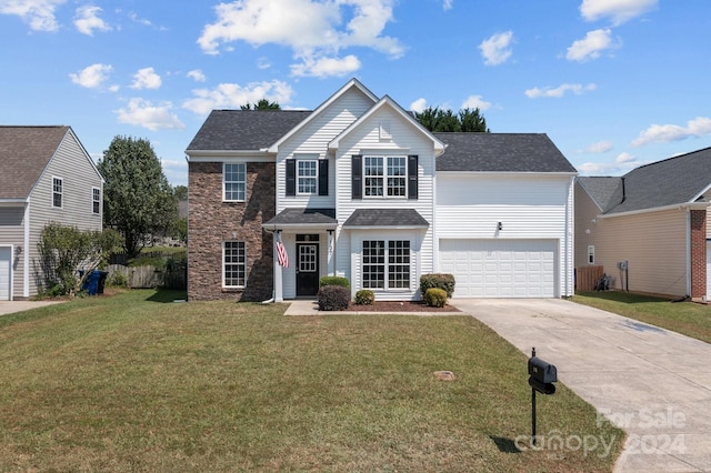 view of property featuring a front lawn and a garage