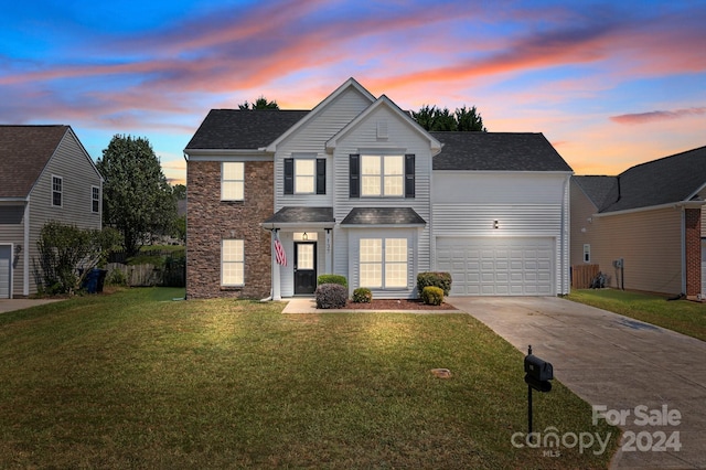 front of property featuring a garage and a yard