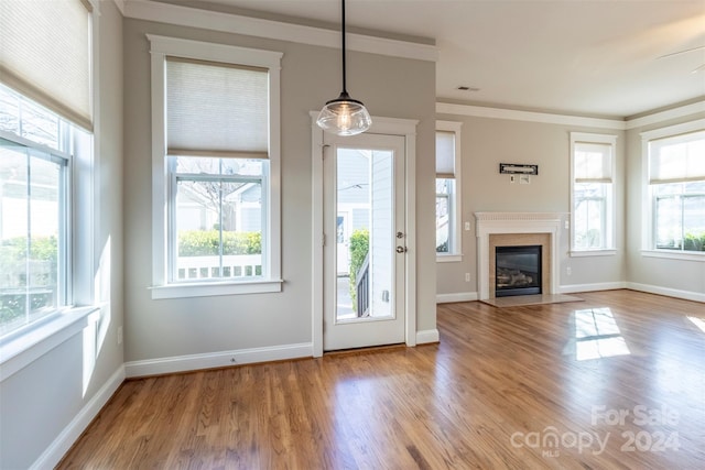 interior space with light wood-type flooring, ceiling fan, and crown molding