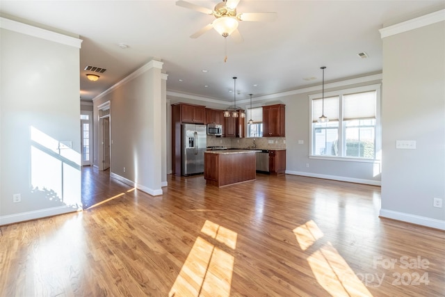 kitchen featuring pendant lighting, hardwood / wood-style floors, a center island, and stainless steel appliances