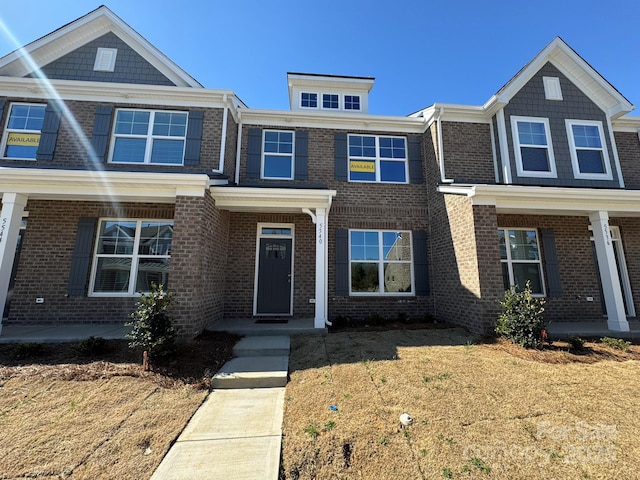 view of front of property featuring brick siding and a front yard