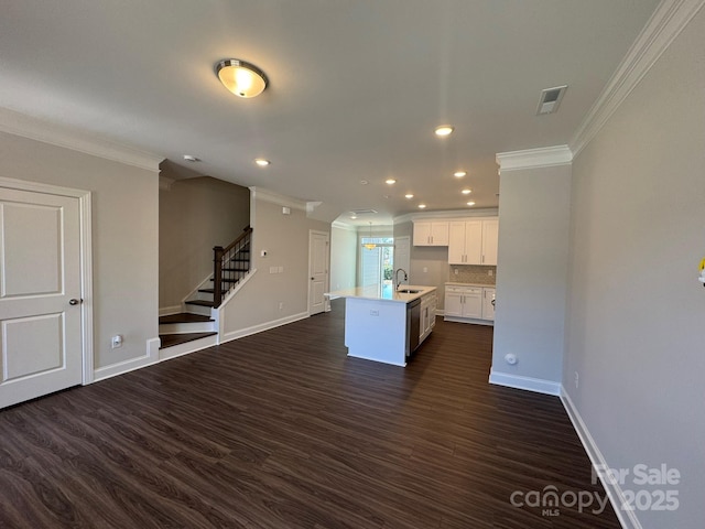 kitchen with a center island with sink, visible vents, white cabinets, open floor plan, and light countertops