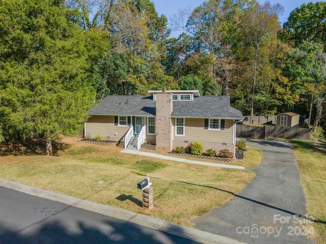 view of front of house featuring a front yard and a storage unit