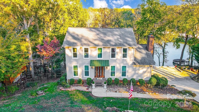 colonial inspired home featuring a front lawn