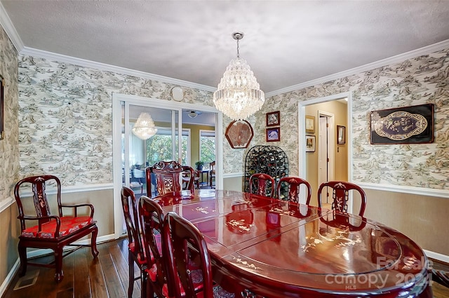 dining space with dark wood-type flooring, a textured ceiling, a notable chandelier, and crown molding