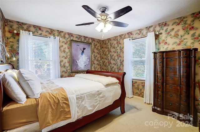 carpeted bedroom with ceiling fan and multiple windows