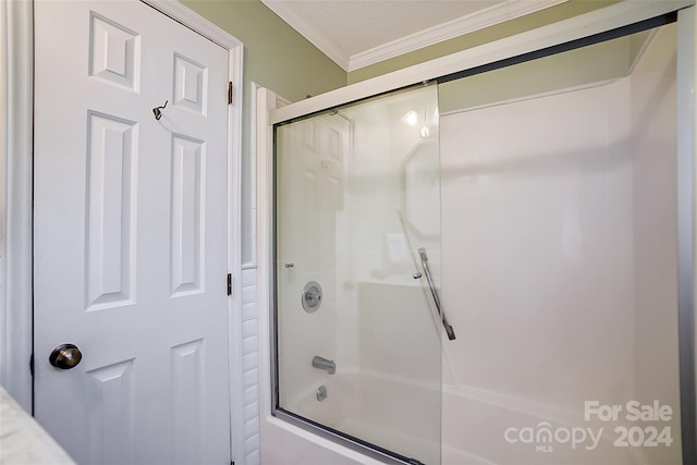 bathroom featuring combined bath / shower with glass door and crown molding