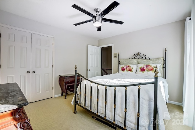 carpeted bedroom featuring ceiling fan and a closet