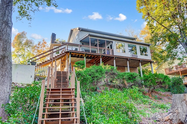 back of house with a sunroom, ceiling fan, and a wooden deck