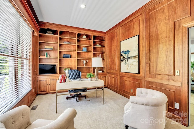 carpeted home office featuring wooden walls, built in features, and ornamental molding