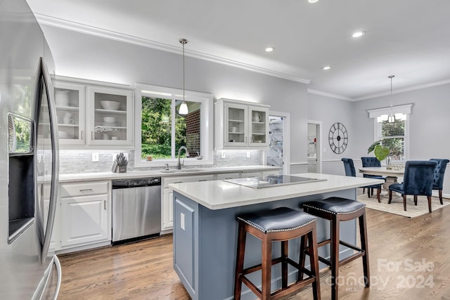4141 Shattalon Dr, Winston Salem, NC 27106 - kitchen featuring appliances with stainless steel finishes, a kitchen island, backsplash, crown molding, and white cabinetry