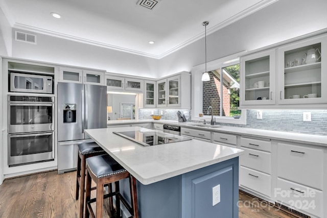 4141 Shattalon Dr, Winston Salem, NC 27106 - kitchen featuring stainless steel appliances, a center island, crown molding, backsplash, and a kitchen breakfast bar