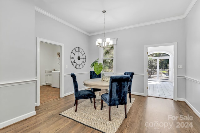 dining room with ornamental molding, wood-type flooring, and a notable chandelier