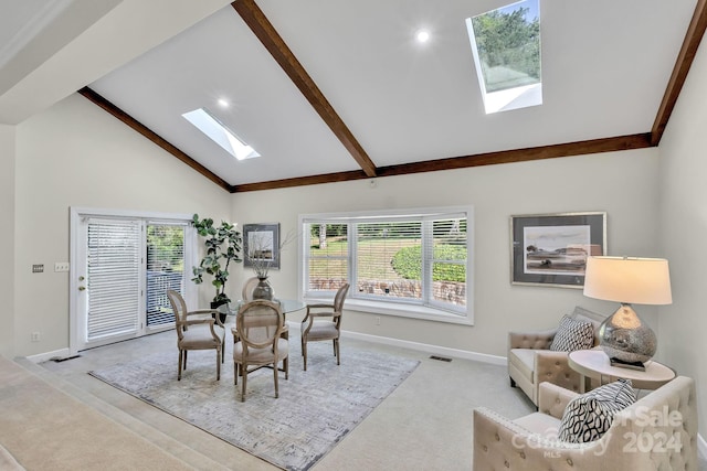 dining area featuring a skylight, high vaulted ceiling, a wealth of natural light, and light colored carpet