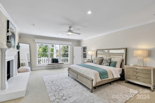 bedroom featuring ceiling fan, light colored carpet, ornamental molding, and a fireplace