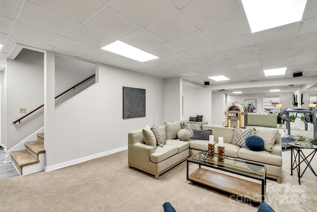 carpeted living room featuring a paneled ceiling