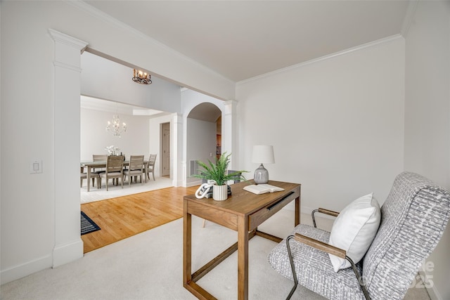 carpeted home office with ornamental molding, a notable chandelier, and decorative columns