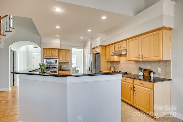 kitchen featuring stainless steel appliances, a center island, light brown cabinets, and under cabinet range hood