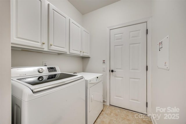 laundry room with light tile patterned floors, cabinet space, and washer and dryer