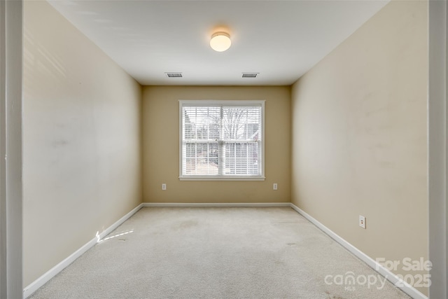 spare room featuring light carpet, baseboards, and visible vents