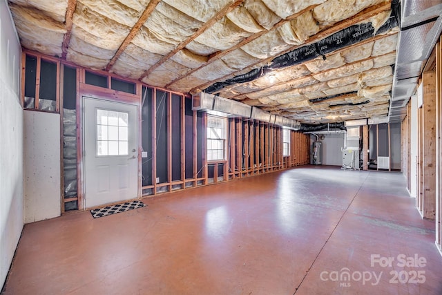 misc room featuring finished concrete floors and water heater