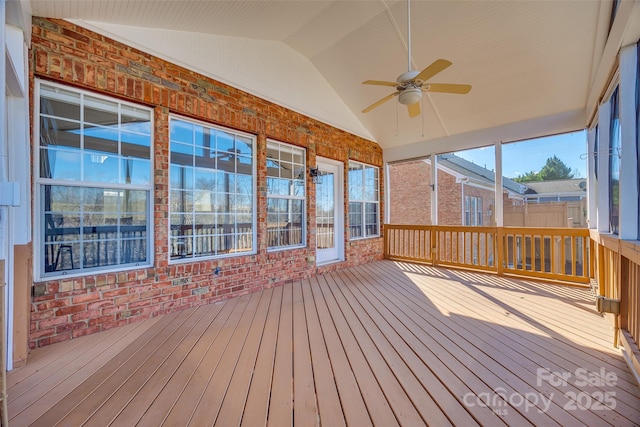 unfurnished sunroom featuring a ceiling fan and lofted ceiling