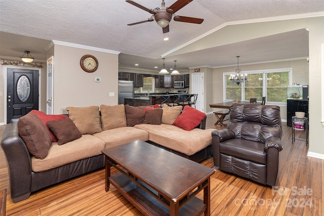 living room with ornamental molding, ceiling fan with notable chandelier, a textured ceiling, light hardwood / wood-style flooring, and lofted ceiling