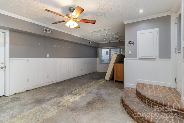 basement with ceiling fan, a textured ceiling, and ornamental molding