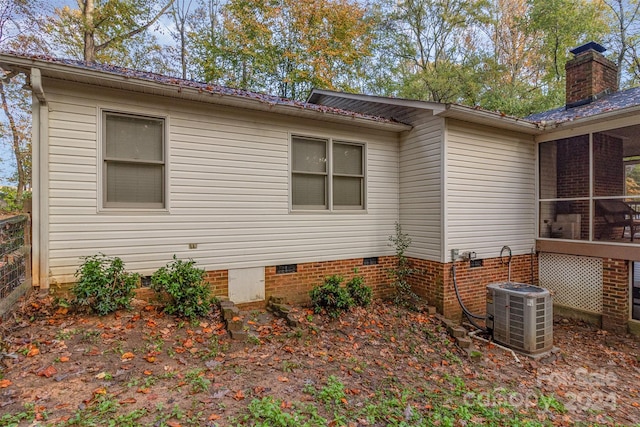 view of property exterior with central AC unit and a sunroom