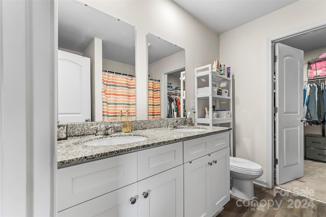 bathroom with hardwood / wood-style flooring, vanity, and toilet