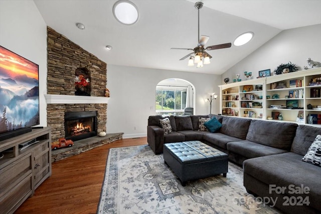 living room with ceiling fan, wood-type flooring, a fireplace, and vaulted ceiling