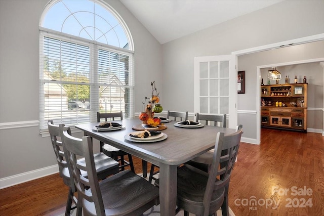 dining space with dark hardwood / wood-style floors and vaulted ceiling