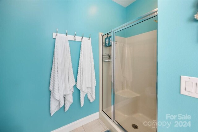 bathroom with tile patterned flooring and an enclosed shower