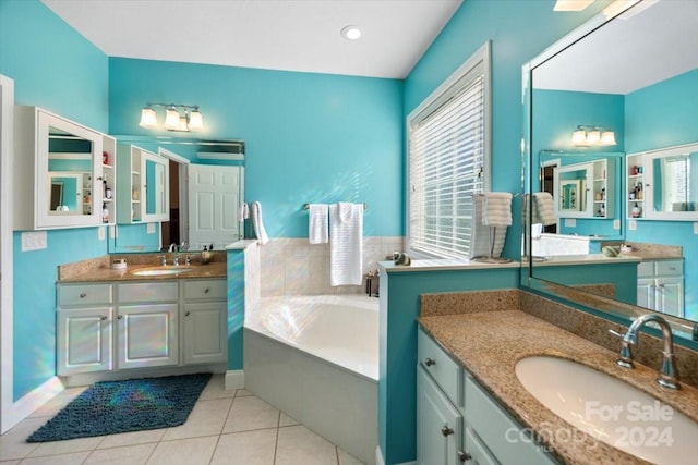 bathroom with a bathing tub, vanity, and tile patterned floors